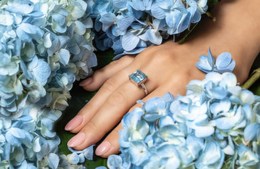 Серебряное кольцо на пальце девушки среди цветов